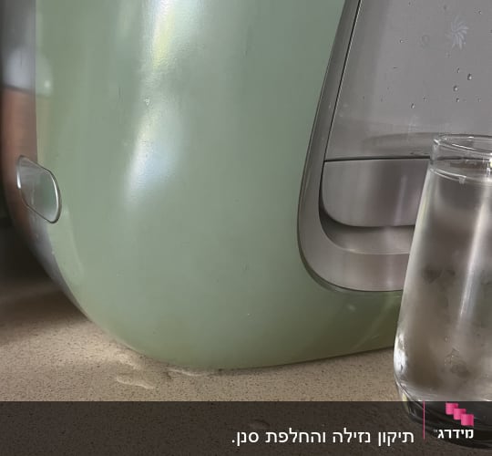 מכונת מים וכוס על משטח מטבח